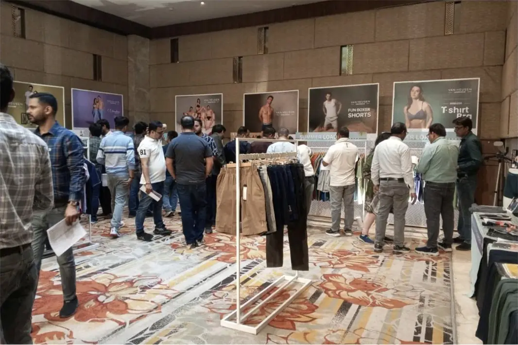 Visitors on an exhibition floor between branded stalls
