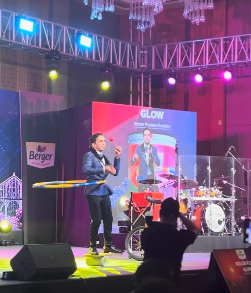 Juggler performing on stage at a brand event with live band